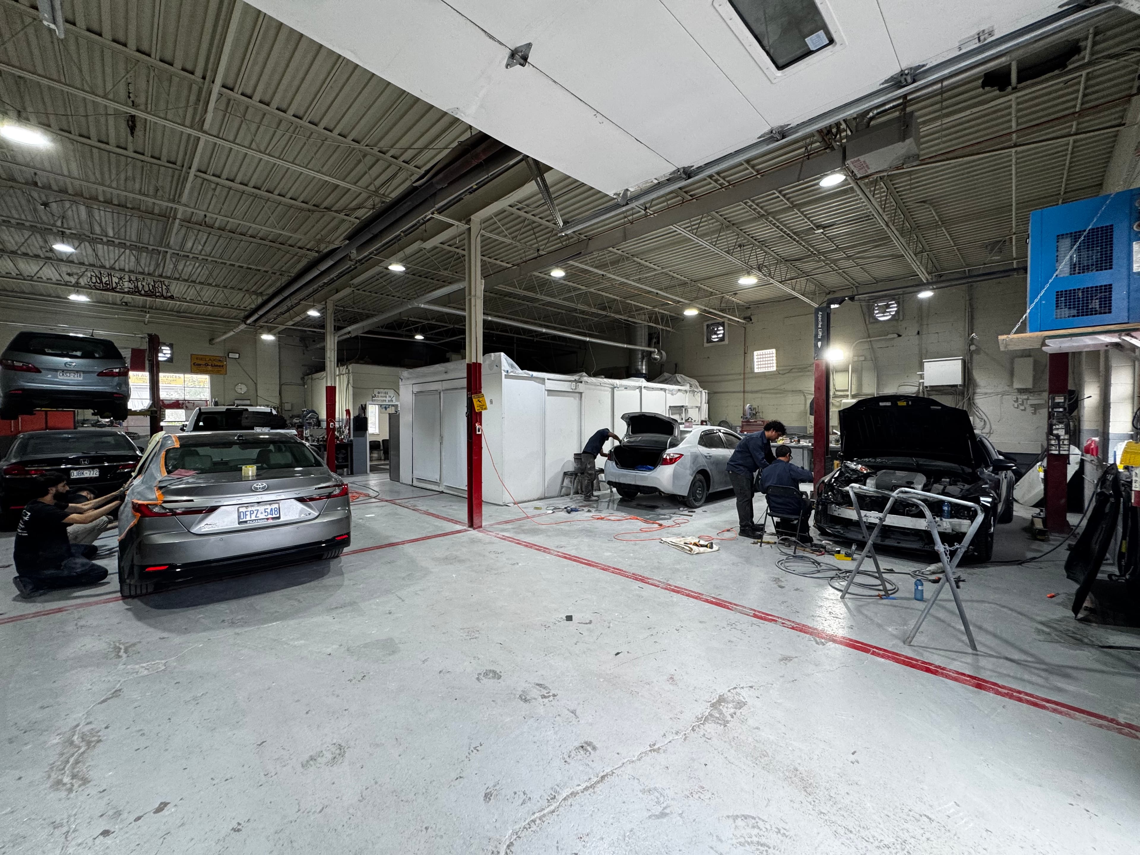 Vehicles being repaired by technicians inside the Greensburg Auto Inc. service garage